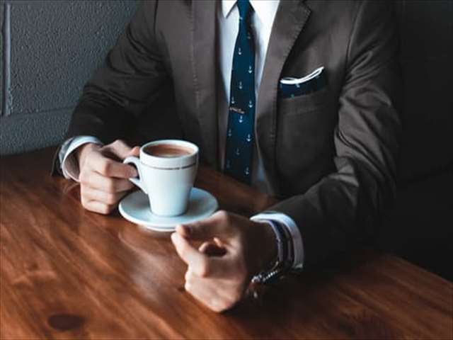 スーツ姿でコーヒーを飲む男性